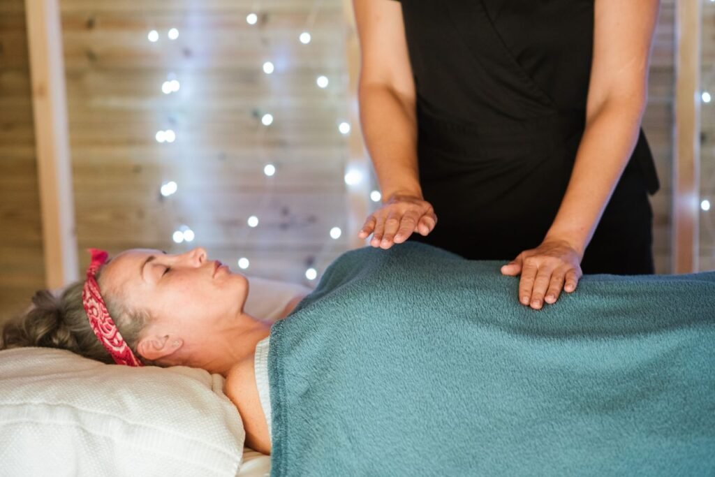 Adult woman resting on comfortable bed in towel while having massage in spa salon